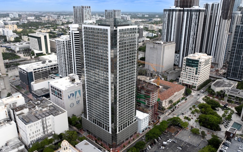 Aerial view of the CMPND Miami high-rise apartment tower surrounded by the downtown Miami skyline and city streets