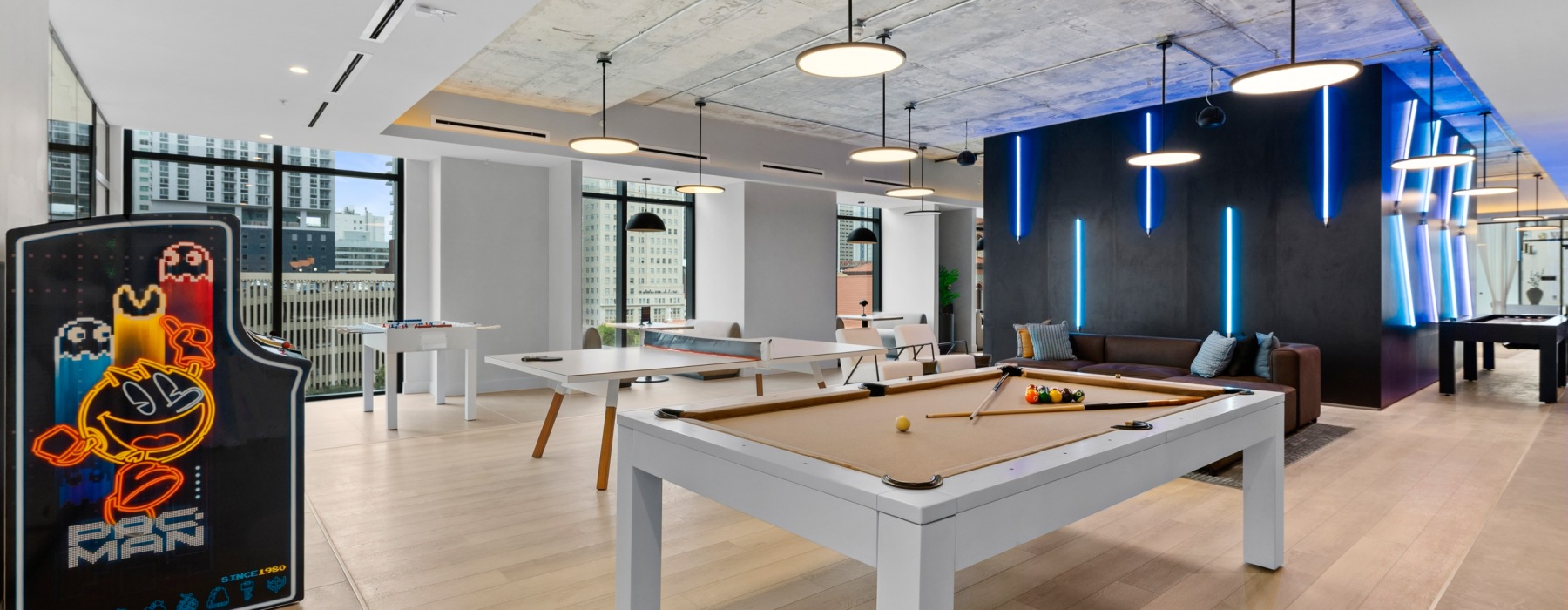 CMPND Miami game lounge with Pac-Man arcade cabinet, billiards table, and neon-lit accent wall