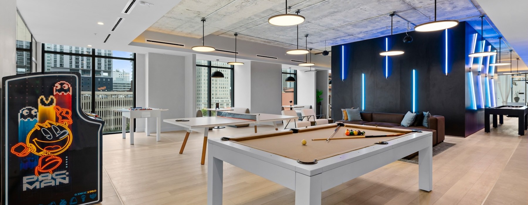CMPND Miami game lounge with Pac-Man arcade cabinet, billiards table, and neon-lit accent wall