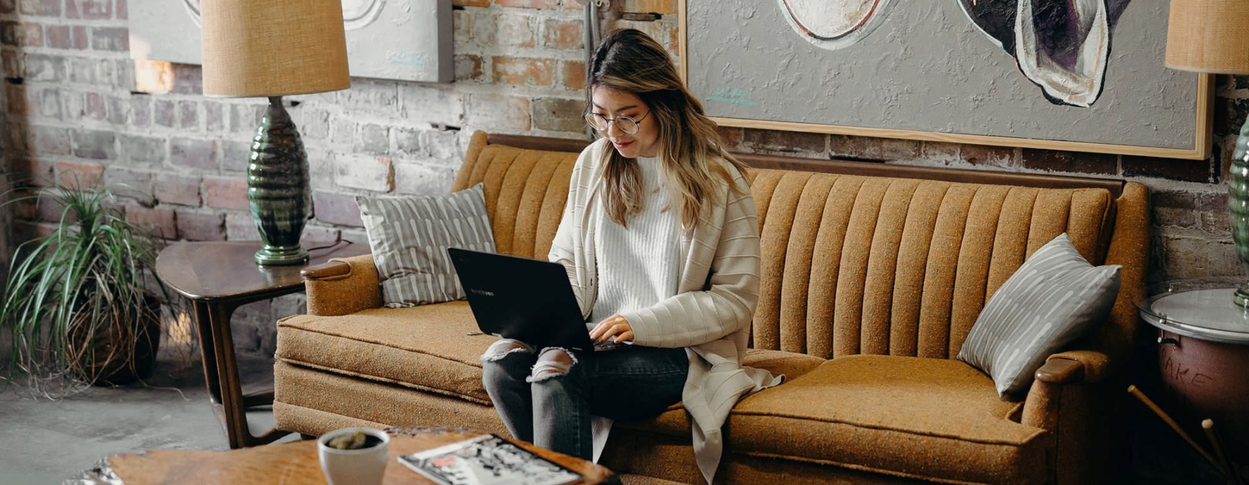a woman sitting on a couch with a laptop