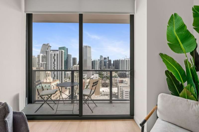 a room with a table and chairs and a window with a view of a city